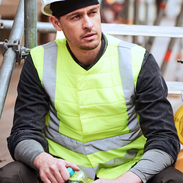 Operaio edile che indossa il gilet refrigerante SX3 con inserti riflettenti di E.COOLINE nel colore giallo segnaletico.